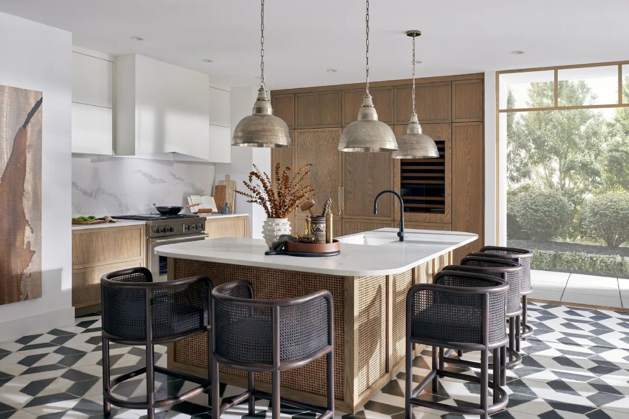 Modern farmhouse kitchen with a massive quartz waterfall island and high-end built-in appliances—luxury NRI kitchen design in Anaikatti, Coimbatore.